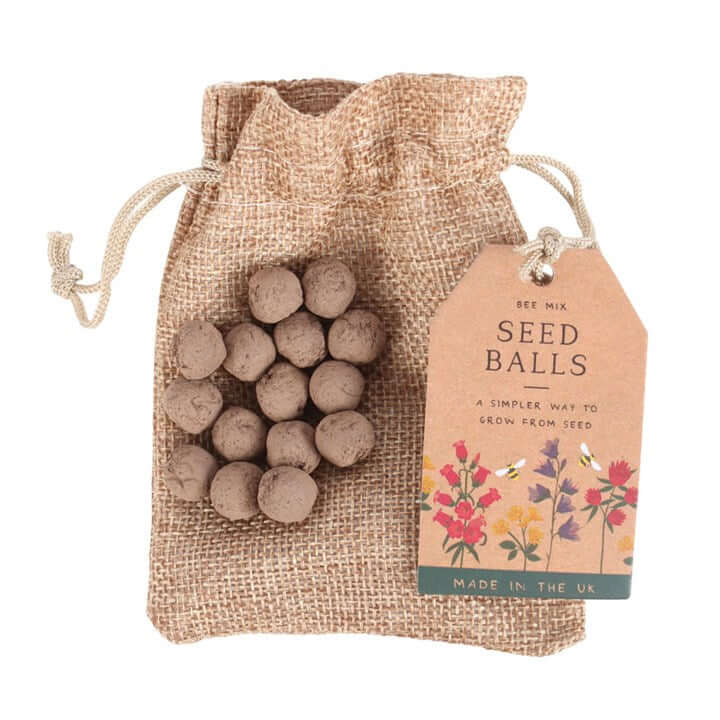 Seed balls in a burlap bag with a tag on a white background