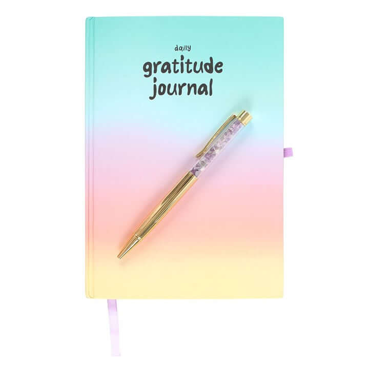 Gradient journal with 'daily gratitude journal' text and a pen on a white background
