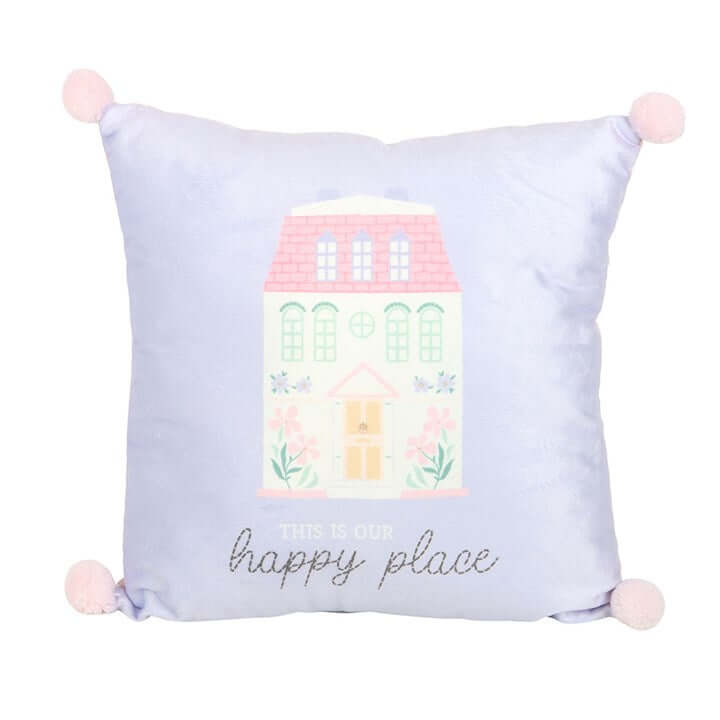 Decorative pillow with a house illustration and 'This is our happy place' text on a light purple background.