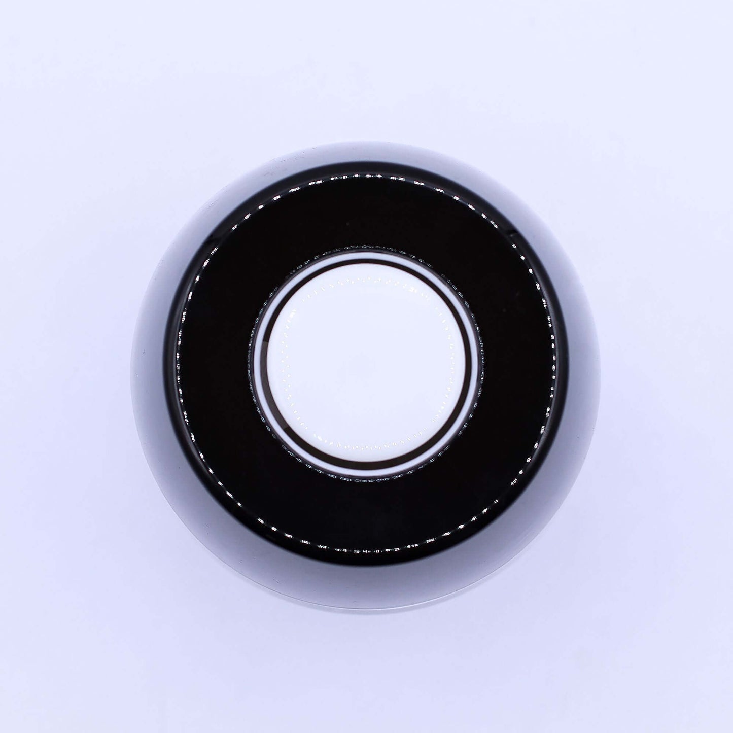 Black round object with white circular center, possibly a magic 8 ball or decorative item.
