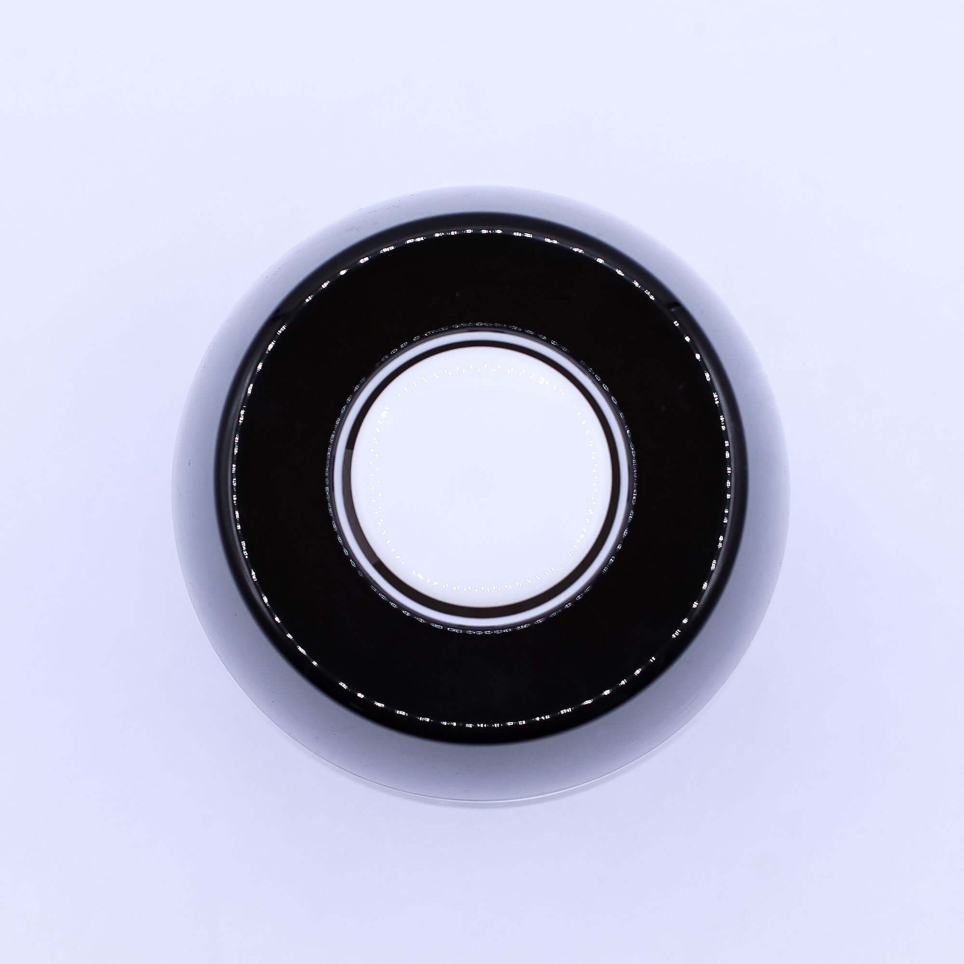 Black round object with white circular center, possibly a magic 8 ball or decorative item.
