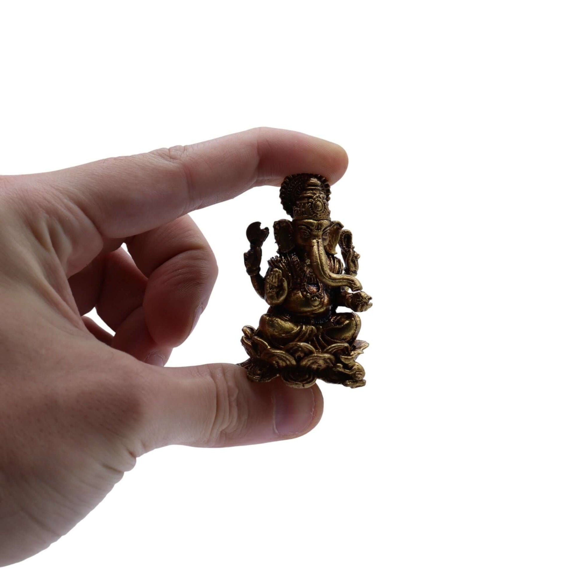 Hand holding a brass Miniature Ganesha Gods statue, showcasing intricate craftsmanship and fine details.