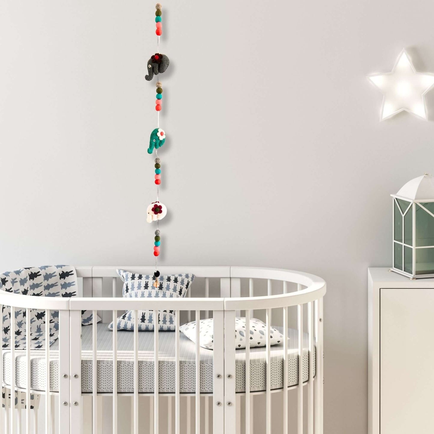 Felt Wall Hanging featuring colorful elephants in a nursery setting above a crib.