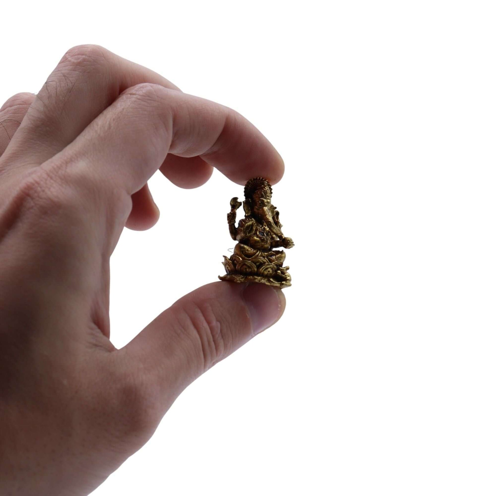 Hand holding a brass miniature Ganesha Gods figurine, showcasing intricate details and craftsmanship.