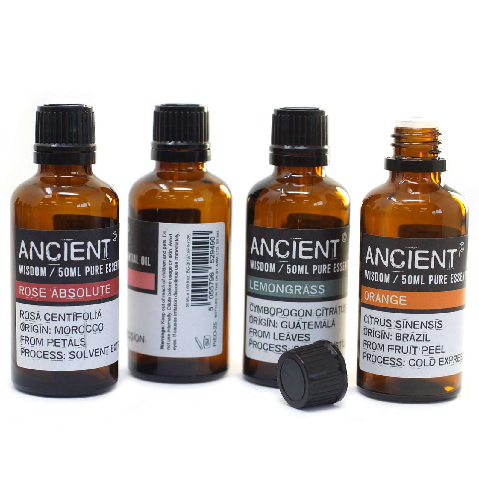 Four bottles of essential oils including Rose Absolute, Lemongrass, and Orange, showcasing their natural scents.