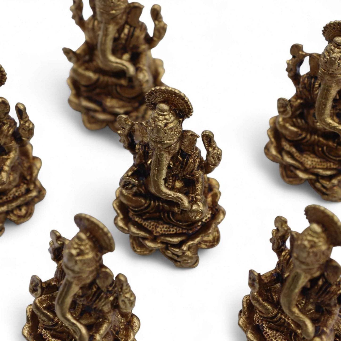Brass Miniature Ganesha Gods figurines arranged on a white background, showcasing intricate details and craftsmanship.