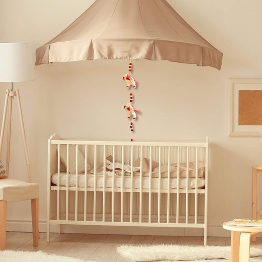 Felt Wall Hanging Unicorns above a nursery crib, featuring colorful unicorn decor for a child's room.