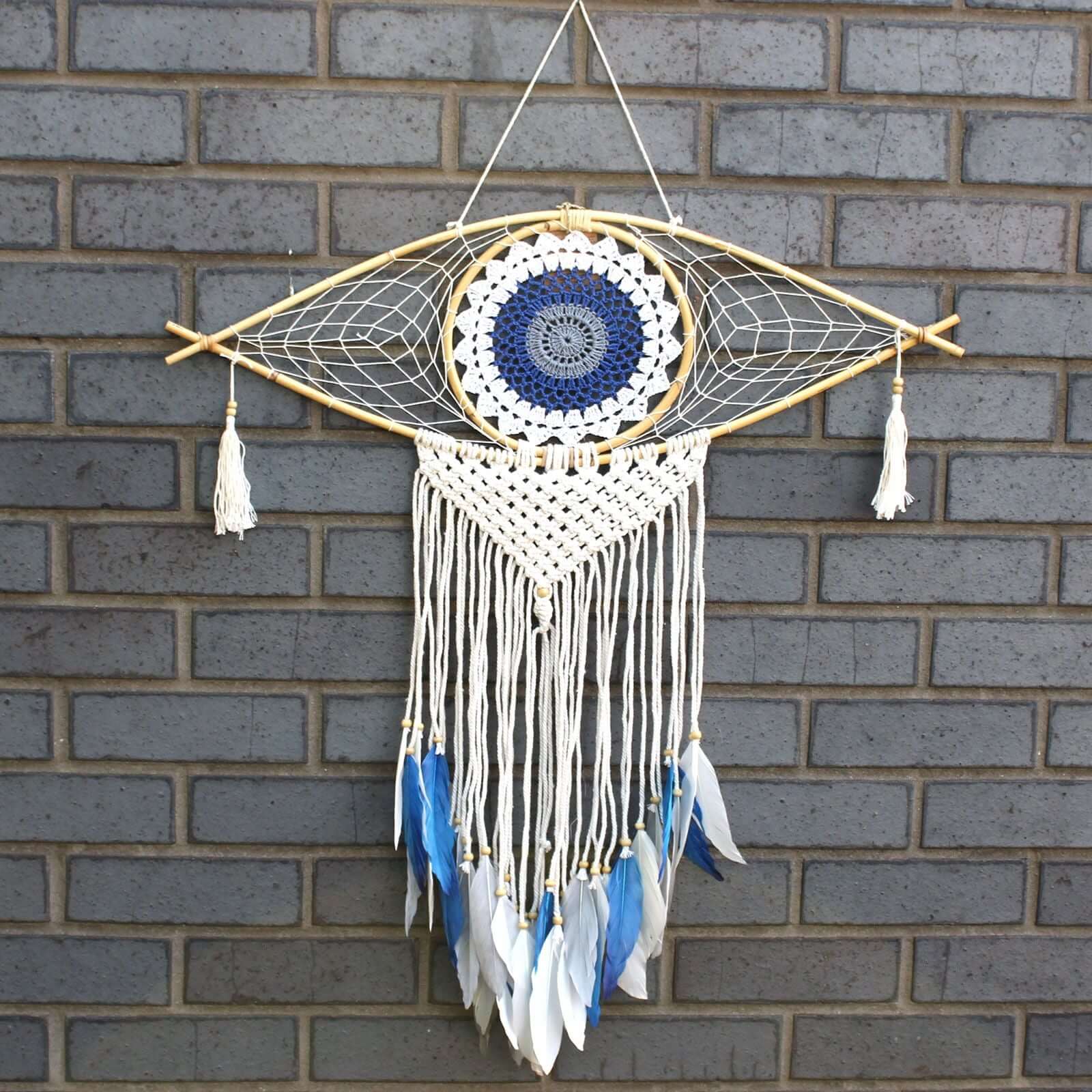 Protection Dream Catcher - Lrg Macrame Evil Eye in White, Blue and Grey design against brick background.