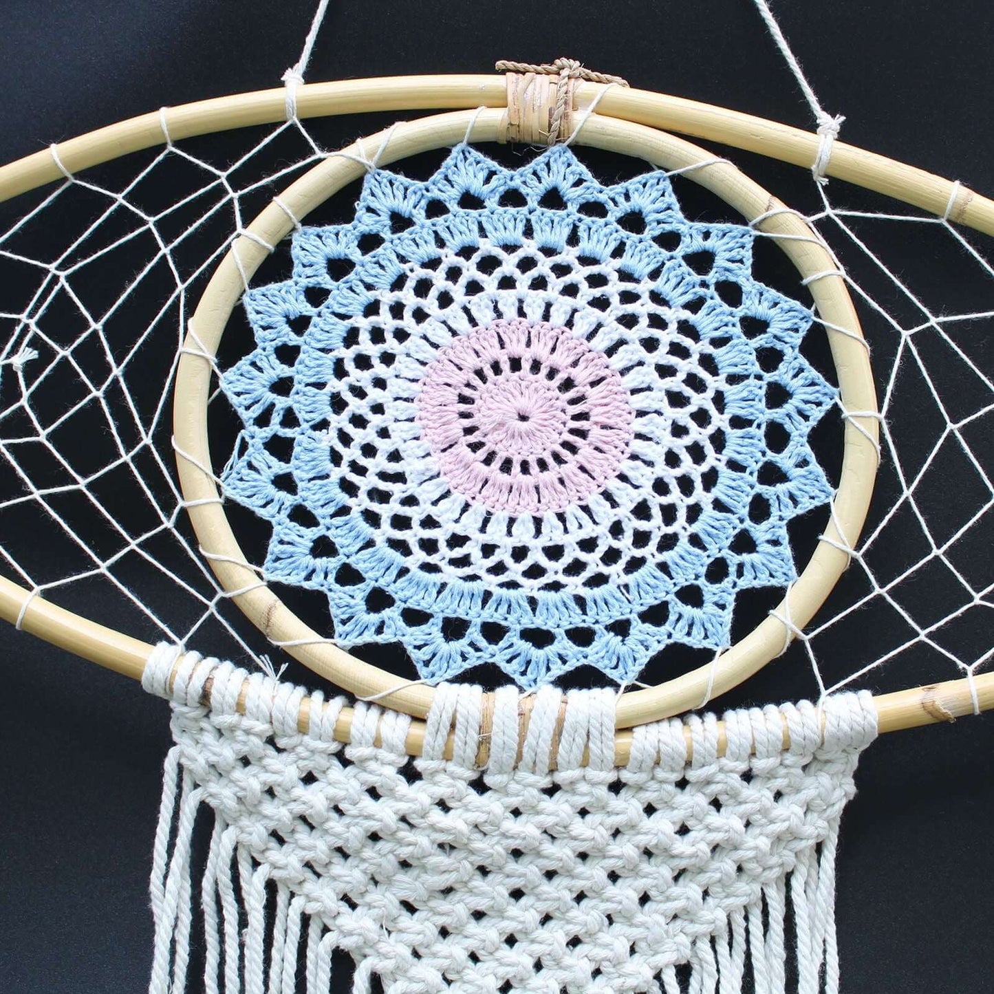 Protection Dream Catcher made of macrame with a blue and pink crochet design and white fringe detail.