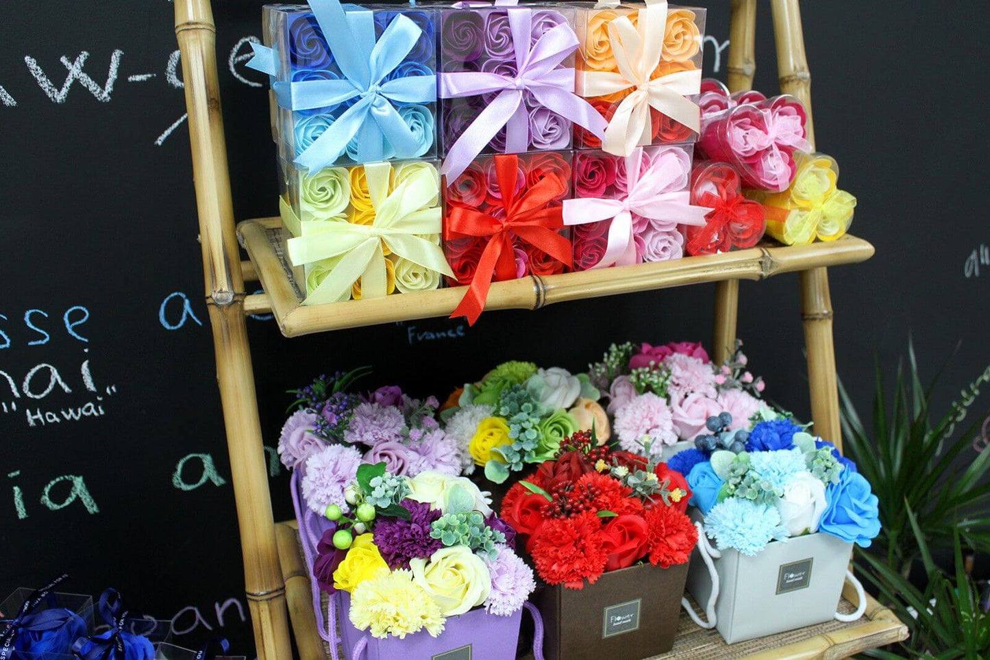 Colorful assortment of Soap Flowers displayed on shelves, featuring pink roses and various vibrant petals.