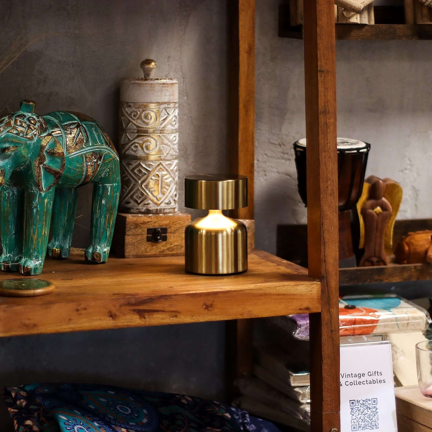 Touch Lamp Flat Mushroom displayed on a wooden shelf with decorative items, showcasing its bronze finish and modern design.