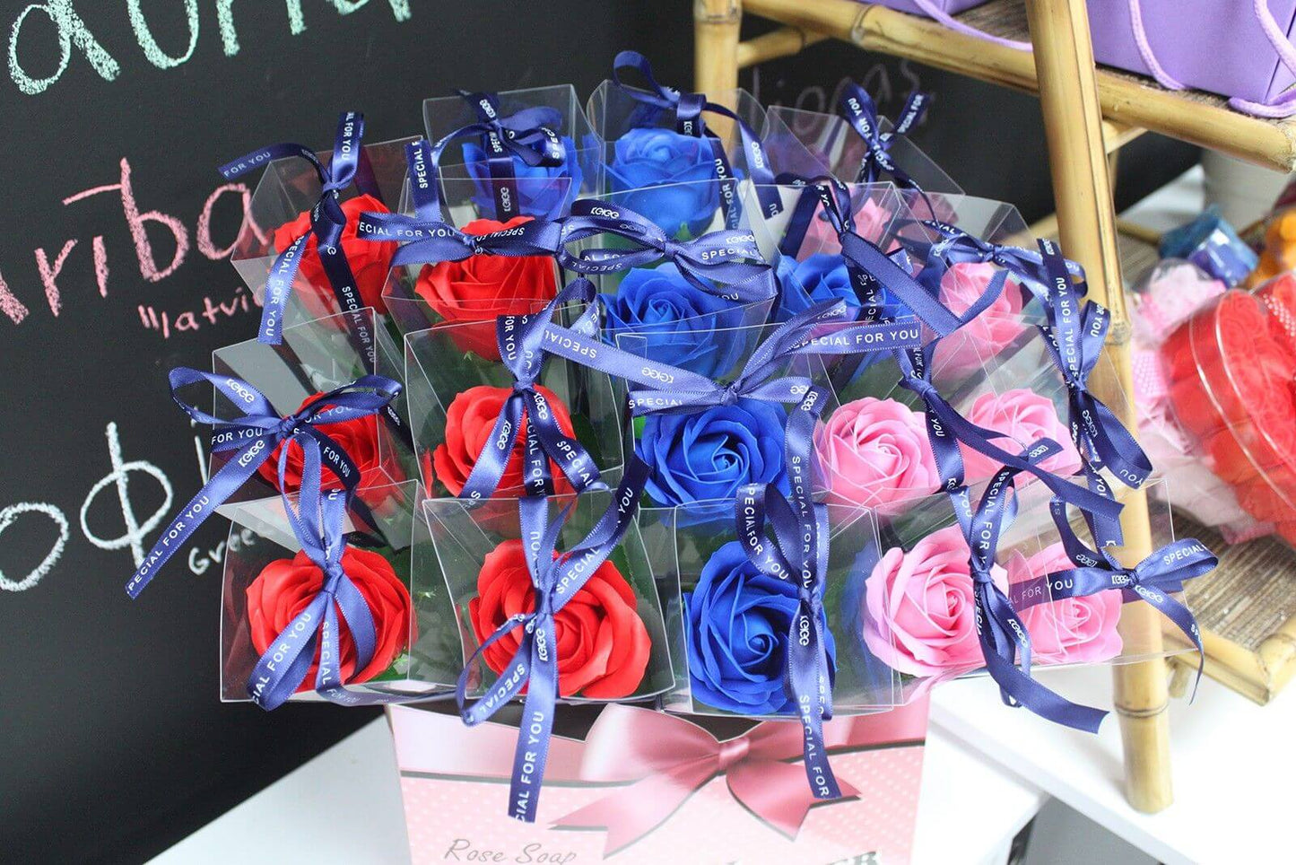 Colorful arrangement of Rose Soap Flowers in vibrant red, blue, and pink, beautifully packaged with decorative ribbons.