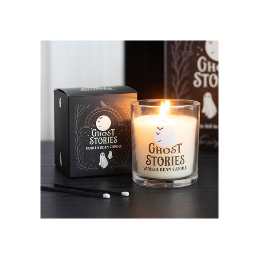 Ghost Stories Vanilla Bean Candle burning beside its box, perfect for spooky nights with a sweet aroma.