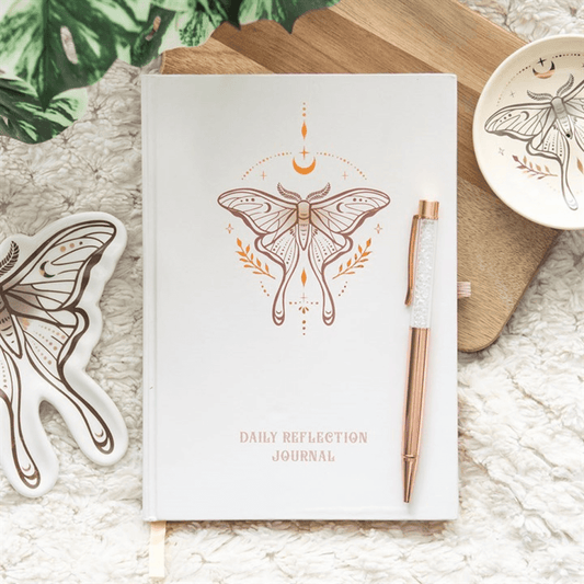 Daily reflection journal with butterfly design and rose gold pen on textured surface