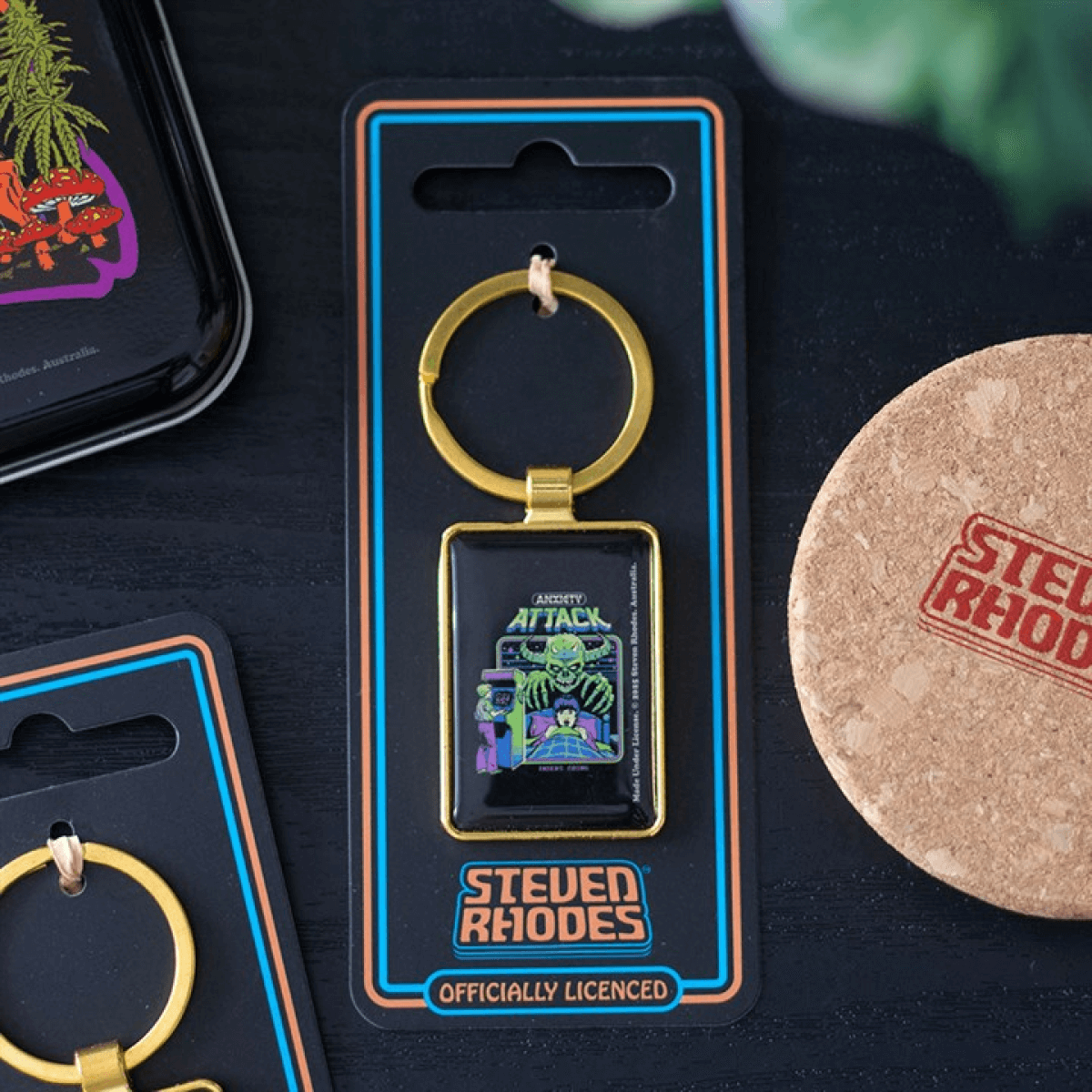 Keychain in packaging with 'Steven Rhodes' branding on a dark surface