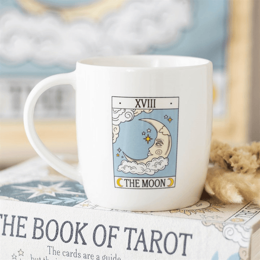 White mug with 'The Moon' tarot card design on a book titled 'The Book of Tarot'.