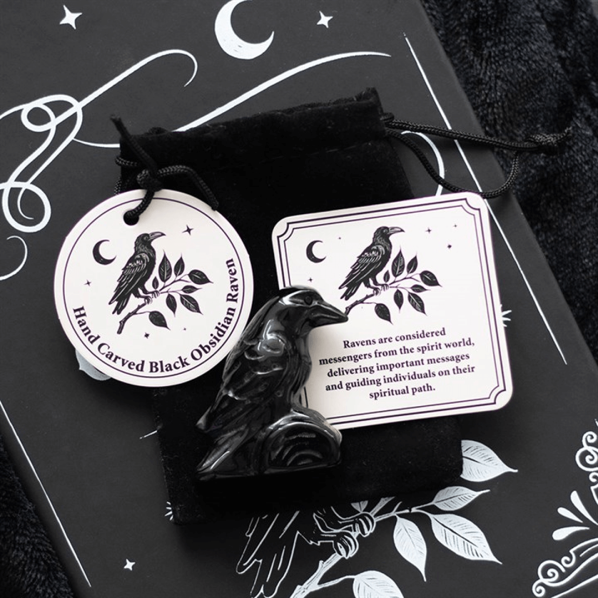 Black raven figurine with packaging on a dark background