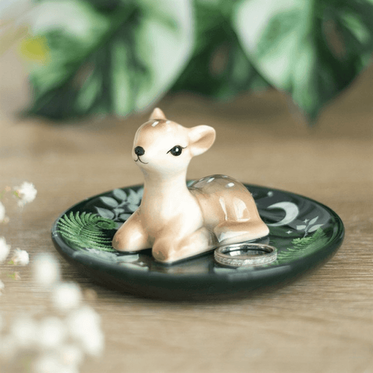 Small deer figurine on a decorative plate with a natural background
