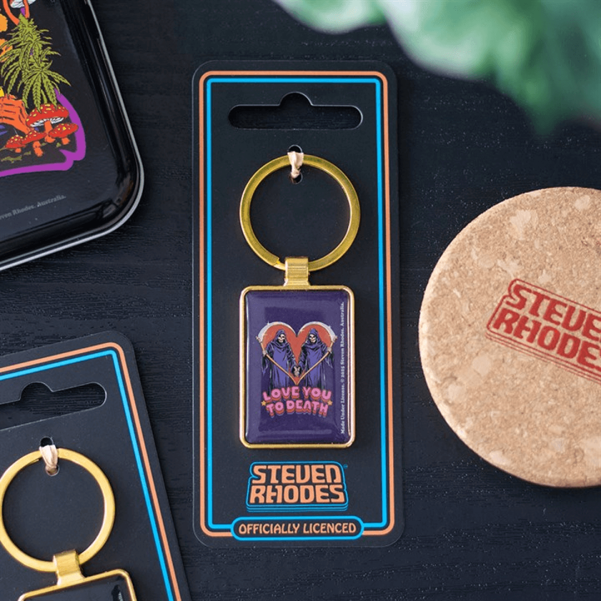 Keychain in packaging with 'Steven Rhodes' branding on a dark surface.
