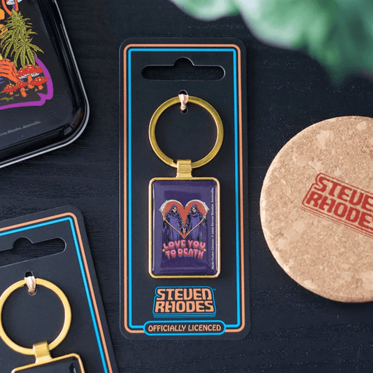Keychain in packaging with 'Steven Rhodes' branding on a dark surface.