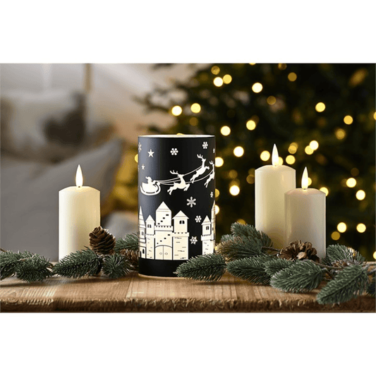 Black Glass Tealight Holder with Sleigh Scene surrounded by candles, creating a cozy holiday atmosphere.