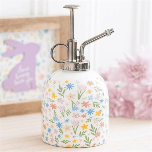 Decorative spray bottle with floral pattern on a light surface.