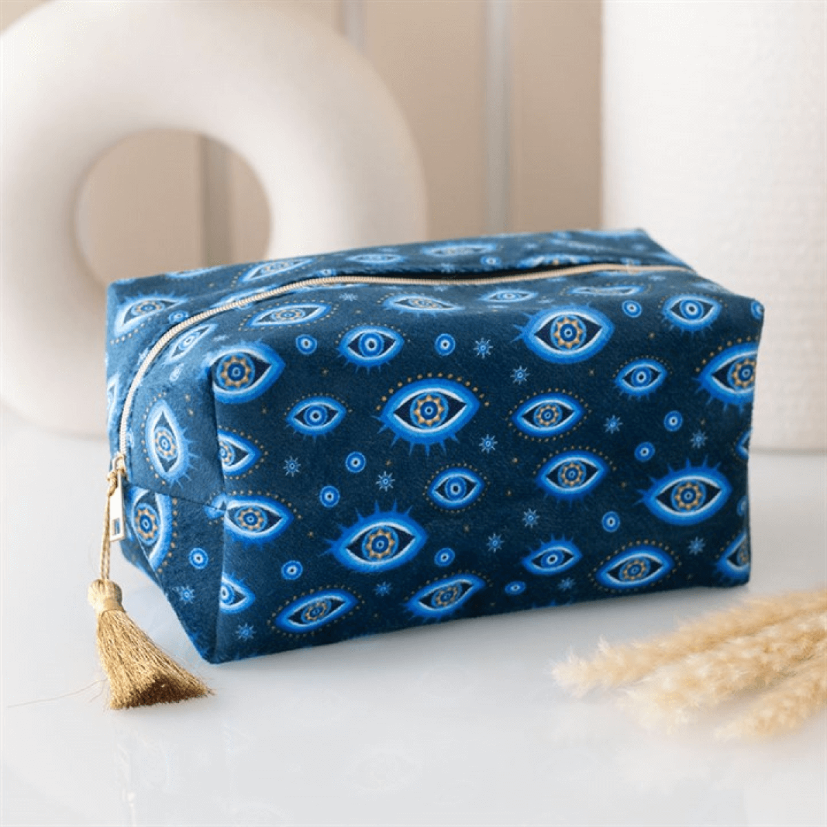 Blue pouch with eye pattern on a white surface