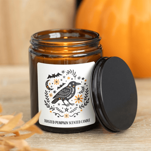 Toasted pumpkin scented candle in apothecary jar featuring a raven design, autumn decor.
