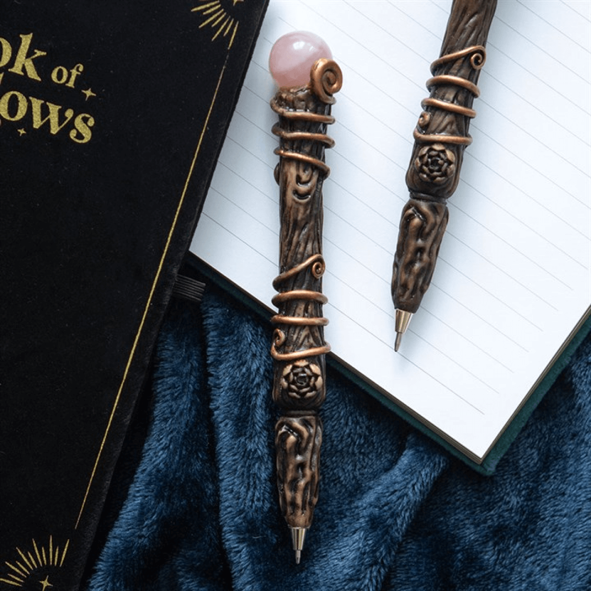 Decorative pen with a pink gemstone on an open book