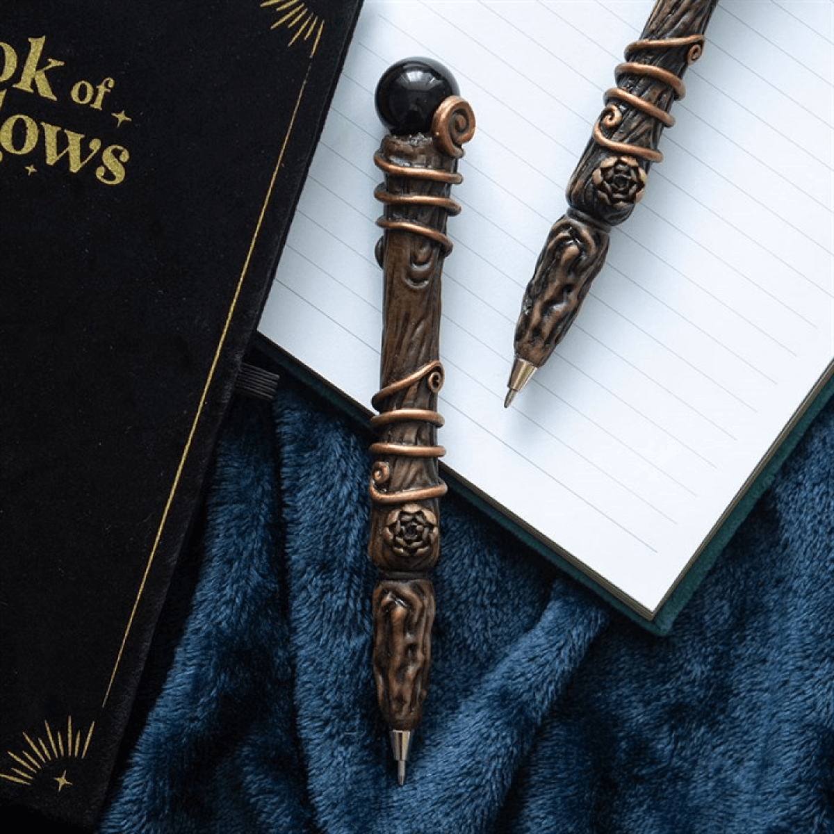 Decorative pen with intricate design on a book of shadows