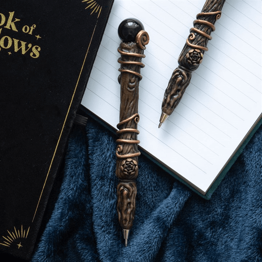 Decorative pen with intricate design on a book of shadows