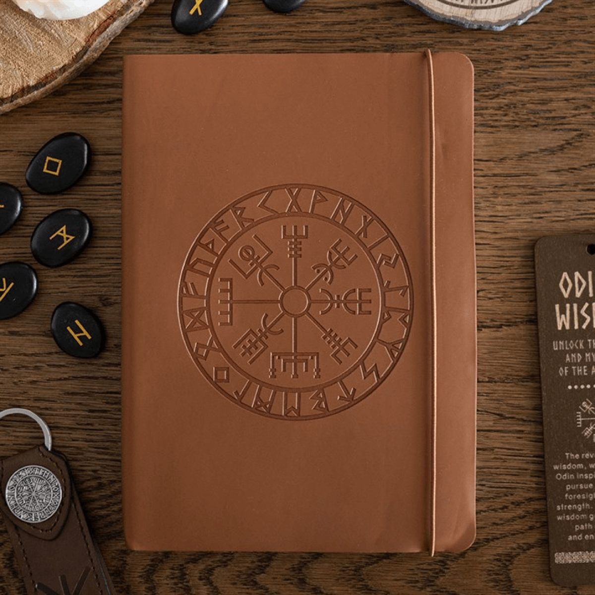 Brown leather notebook with embossed design on a wooden surface