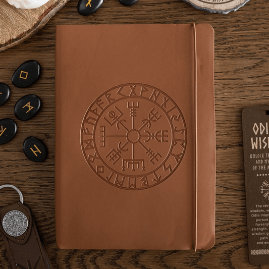 Brown leather notebook with embossed design on a wooden surface