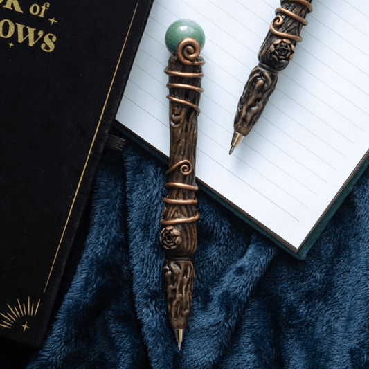 Decorative pen with intricate designs on a blue fabric background