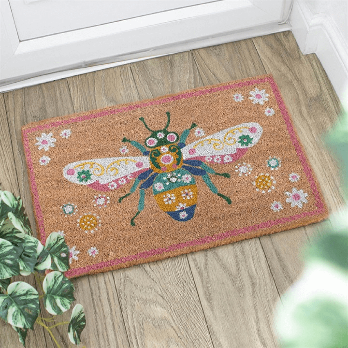 Decorative doormat with a bee design on a wooden floor
